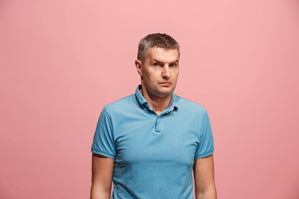 Suspiciont. Doubtful pensive man with thoughtful expression making choice against pink background - Photo, Image