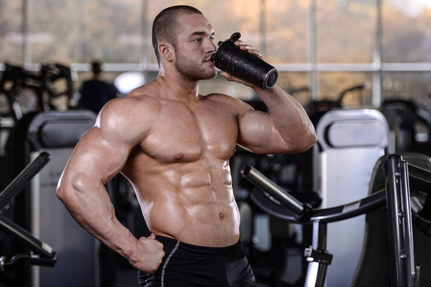Brutal strong bodybuilder athletic men pumping up muscles with d - Φωτογραφία, εικόνα