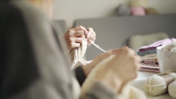 Primo piano di mani femminili che lavorano vestiti di lana a maglia. Due donne maglieria abbigliamento
 - Filmati, video