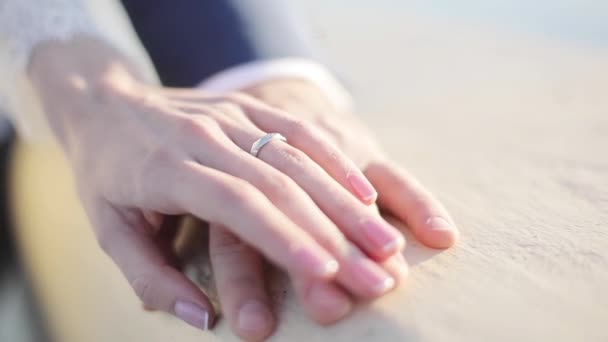 Male female hands with wedding rings close up hold stroking each other sunny light blurred background shallow depth of field. Nail polish artist master. Bridal fidelity family connection unity concept - Footage, Video
