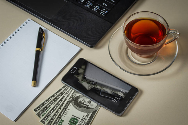 A table of a successful businessman with dollars and gadgets - Photo, Image