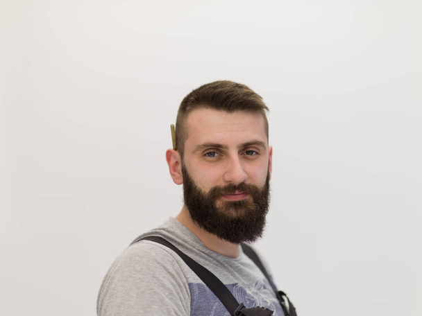 portrait of bearded hipster handyman with pen behind ear isolated on white background - Fotografie, Obrázek