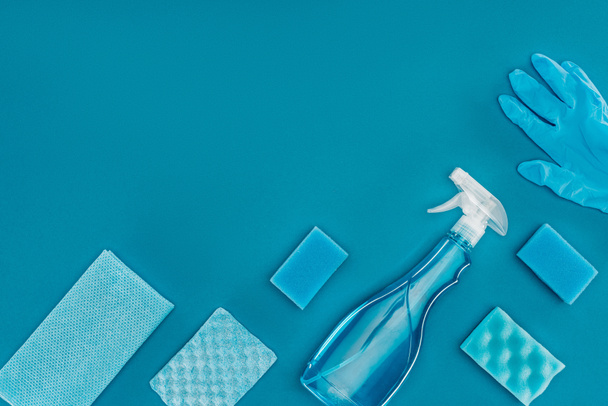 vista superior de la botella de spray con esponjas de lavado azules aisladas en azul
 - Foto, Imagen