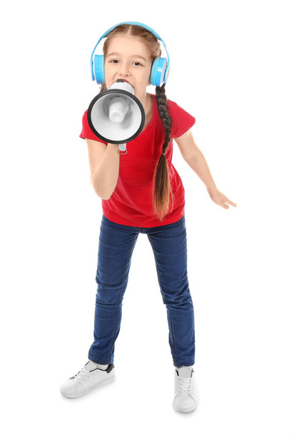 Little girl with headphones shouting into megaphone on white background - Fotó, kép