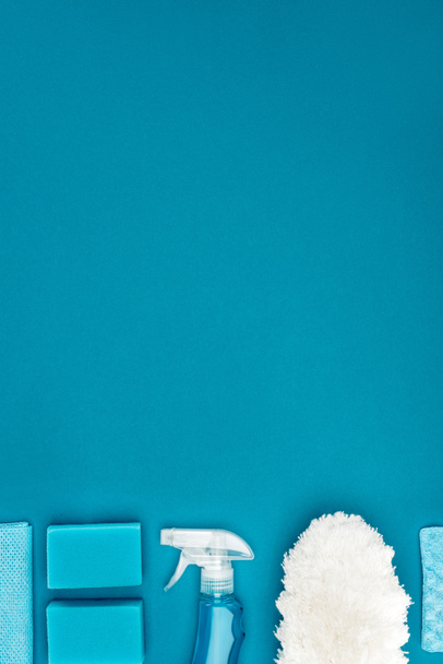 κάτοψη του πλύσιμο σφουγγαριών και τις καθαρίζοντας προμήθειες που απομονώνονται σε μπλε - Φωτογραφία, εικόνα