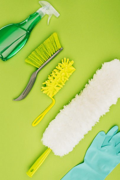 top view of different cleaning brushes and rubber glove isolated on light green - Foto, imagen