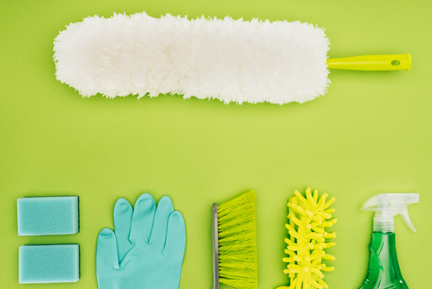 vista superior da escova de poeira e suprimentos de limpeza isolados em verde claro
 - Foto, Imagem