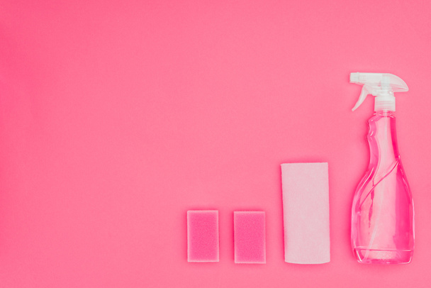 vista superior de esponjas de lavado de color rosa, trapo y botella de spray aislado en rosa
 - Foto, Imagen