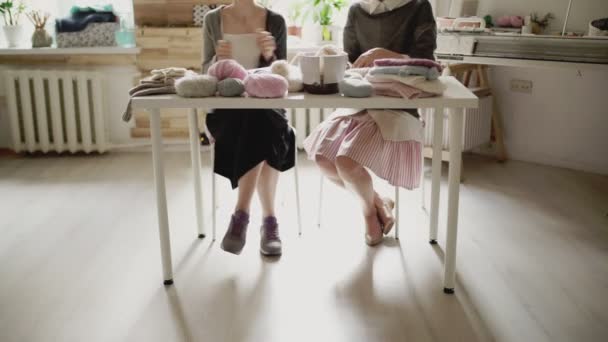 Pernas femininas sentadas à mesa e agulhas de tricô. Mulher de tricô
 - Filmagem, Vídeo