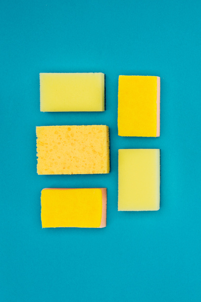 vista superior de esponjas de lavado amarillas aisladas en azul
 - Foto, Imagen