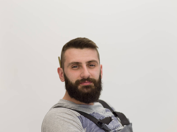 portrait of bearded hipster handyman with pen behind ear isolated on white background - Фото, зображення