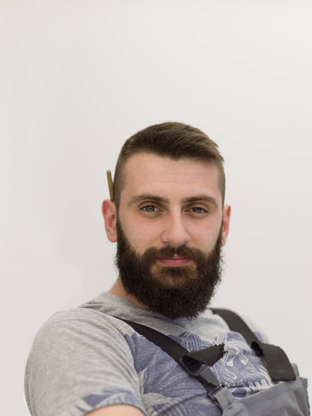 portrait of bearded hipster handyman with pen behind ear isolated on white background - Fotografie, Obrázek
