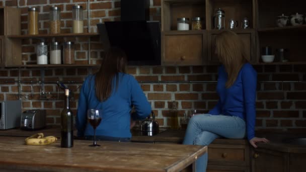 Happy female friends enjoying wine in the kitchen - Πλάνα, βίντεο