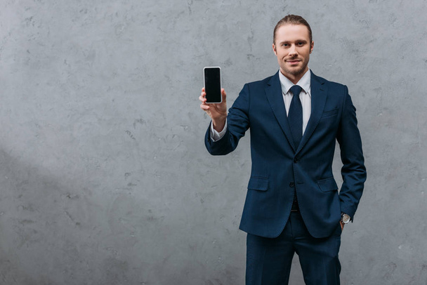 young handsome businessman showing smartphone at camera - Zdjęcie, obraz