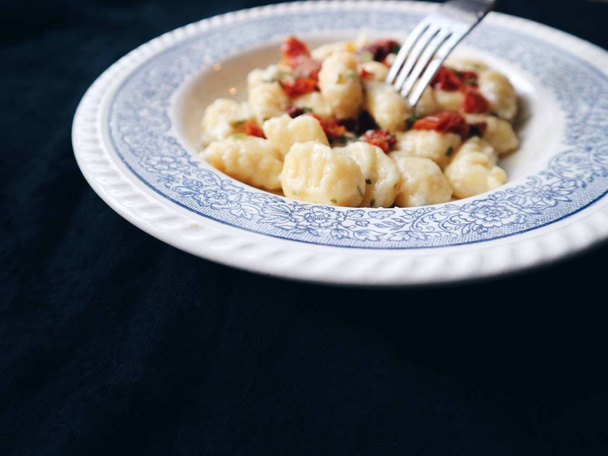 Gnocchis traditionnels italiens. Gnocchi italien traditionnel aux tomates sèches, fromage parmesan, beurre d'ail fondu aux herbes
.  - Photo, image