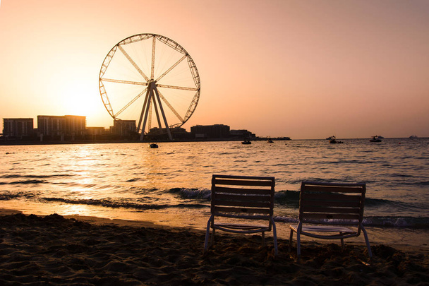 Два лежака с видом на колесо обозрения Ain Dubai на пляже JBR
 - Фото, изображение