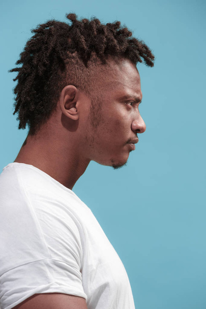 The young emotional angry afro man on blue studio background - Valokuva, kuva