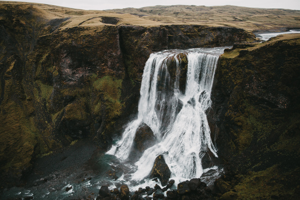 Widok z lotu ptaka spektakularny wodospad Fagrifoss i skał w Islandii - Zdjęcie, obraz
