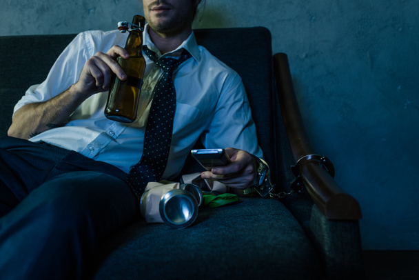 recortado disparo de alcohol adicto hombre en camisa blanca viendo la televisión y beber cerveza después del trabajo
 - Foto, Imagen