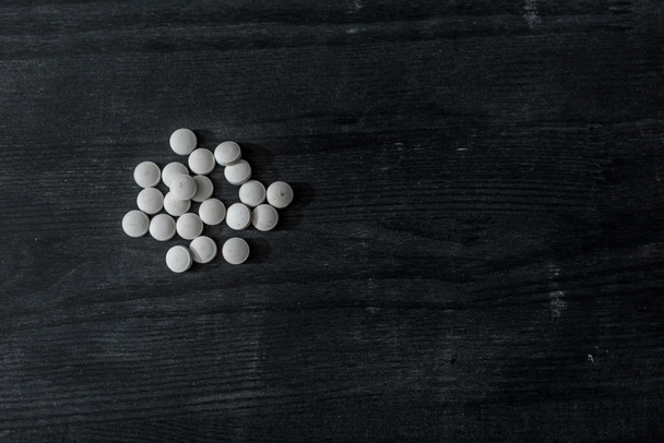 vista dall'alto di pillole mdma sulla superficie di legno nero
 - Foto, immagini