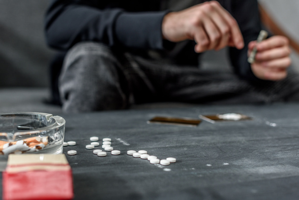cropped shot of addicted man with various drugs on table - Фото, зображення
