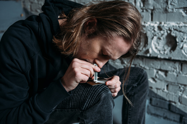 крупним планом знімок залежного чоловіка, що нюхає кокаїн з кредитної картки
 - Фото, зображення