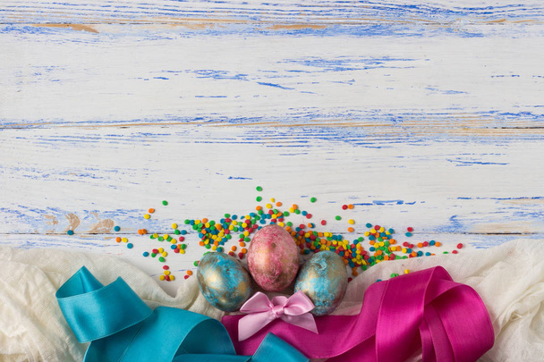 Ovos de Páscoa, fitas, doces multicoloridos Ornamentos no Woode
 - Foto, Imagem