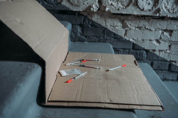 gros plan des seringues d'héroïne sur carton et dans les escaliers
 - Photo, image