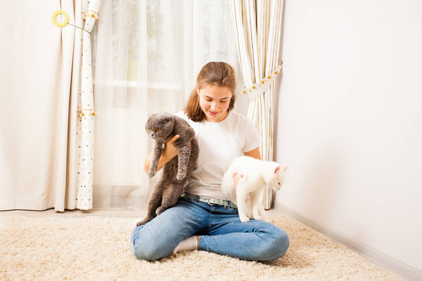 pretty girl is playing with her cats - Fotoğraf, Görsel