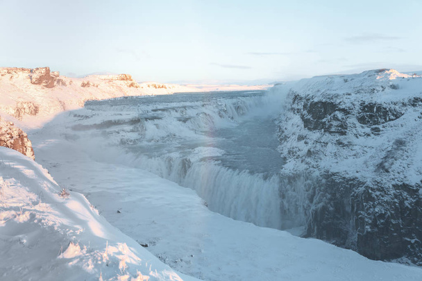 雪に覆われた岩とグトルフォスの滝と美しいアイスランドの風景 - 写真・画像