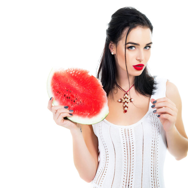 Beautiful young woman holding and eating slice of ripe red fresh - Foto, imagen