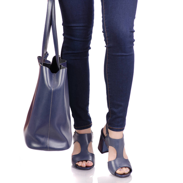 青い革製のバッグ ハンドバッグ ブルー サンダル靴、ジーンズの女性の足 - 写真・画像