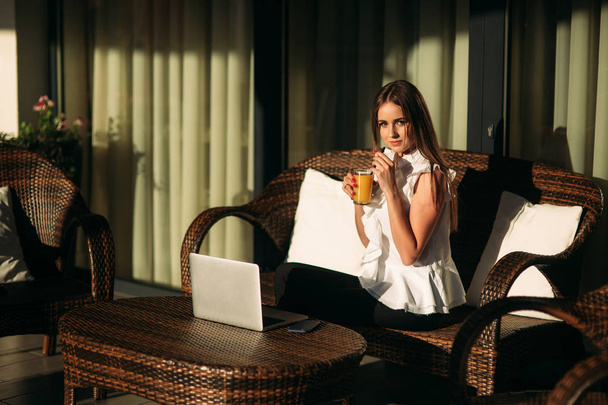 Joven hermosa chica utilizar un ordenador portátil durante un descanso en el trabajo. Día soleado de verano
 - Foto, imagen