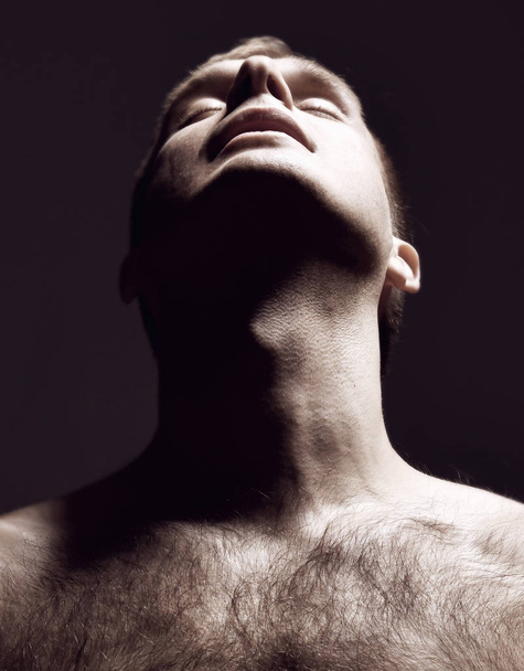 Closeup portrait of sexy handsome topless male model on dark look up  - Фото, зображення
