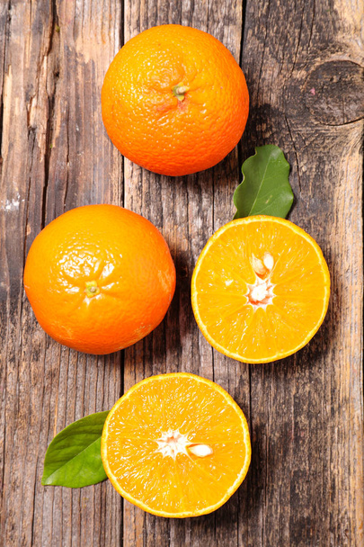 fresh oranges with leaves on wooden background - Φωτογραφία, εικόνα