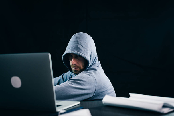 muž hacker skrývá svou tvář pod kapotou - Fotografie, Obrázek