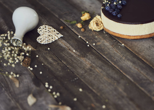 Pyszne ciasto z polewą czekoladową i jagody na drewnianym stole rustykalne - Zdjęcie, obraz