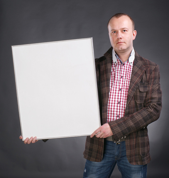 Portrait of a serious male holding blank white card - Foto, Imagen
