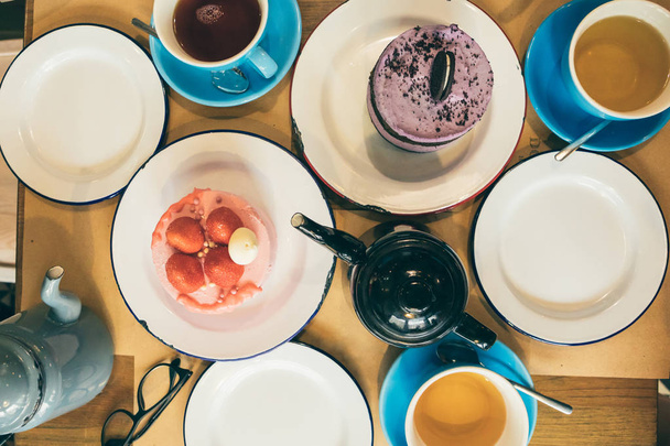 een eettafel met snoepjes en een kop en een waterkoker met thee. van bovenaf bekijken - Foto, afbeelding