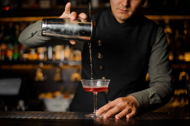 Barman pouring alcoholic drink with campari into the cocktail glass - Photo, Image