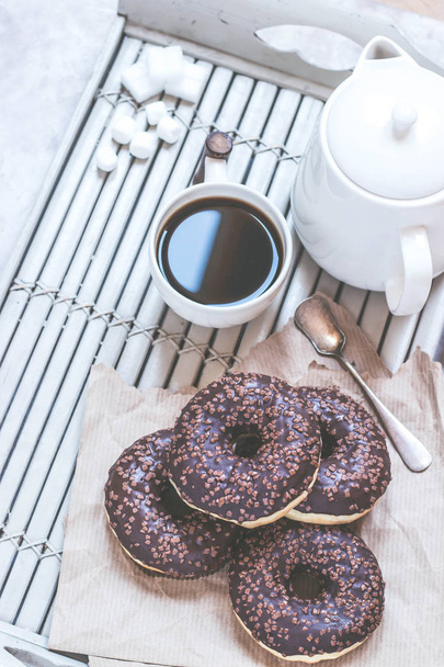 Chocolate donuts and coffee , weekend morning table. Breakfast on a wooden tray. Vintage colors. - Fotografie, Obrázek