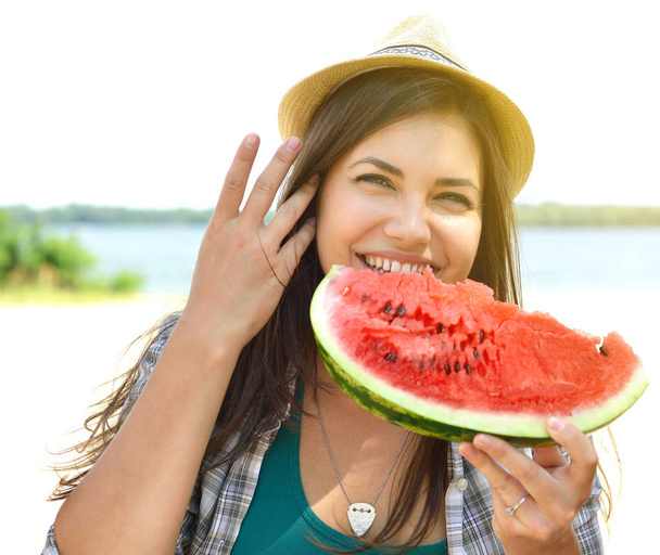 Happy young couple eating watermelon on the beach. Youth lifesty - Foto, imagen