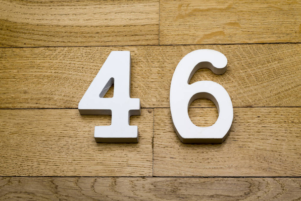 Фигура 46 на деревянном паркетном полу
. - Фото, изображение