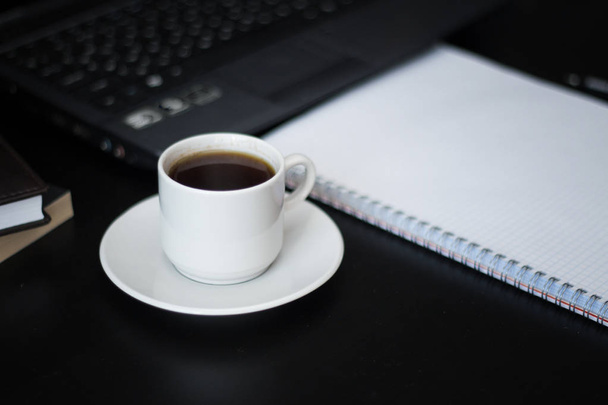 working place with a cup of coffee for business people on black table - Foto, Bild