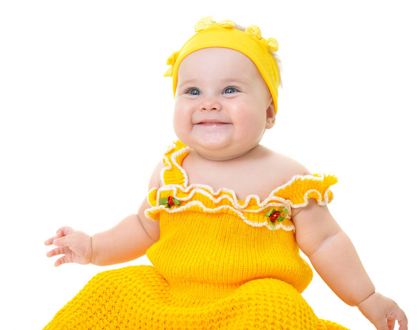 Adorable baby girl pozowanie i szczęśliwy uśmiechający się w studio na żółto  - Zdjęcie, obraz