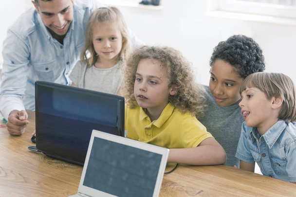 Children working together on laptop - Φωτογραφία, εικόνα