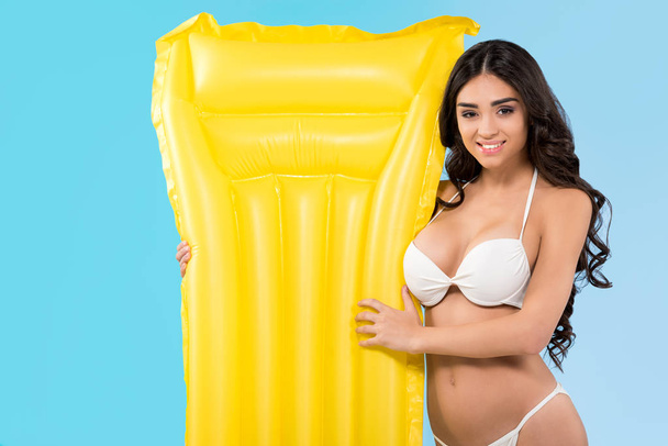 beautiful girl with yellow inflatable mattress, isolated on blue - Photo, Image
