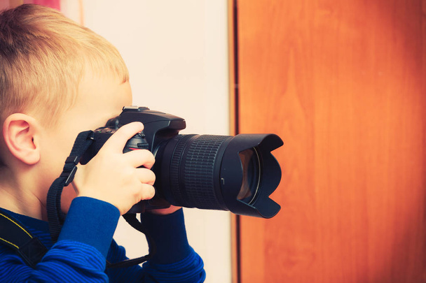 Kid playing with big professional digital camera - Photo, Image
