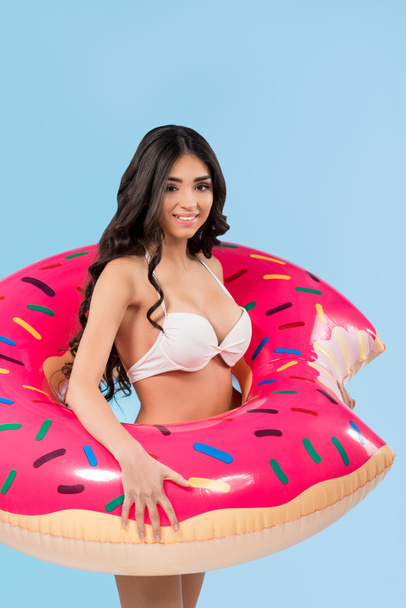 attractive girl in swimsuit posing with inflatable donut ring, isolated on blue  - Fotografie, Obrázek