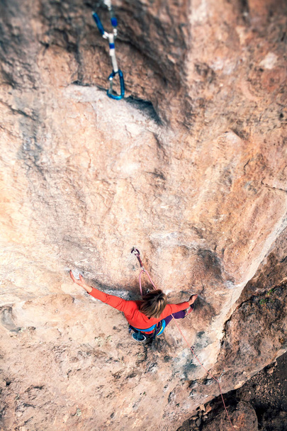 Una mujer sube a la roca
. - Foto, imagen